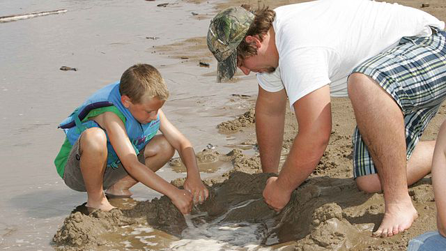Apa és fia játszik a vízparton
