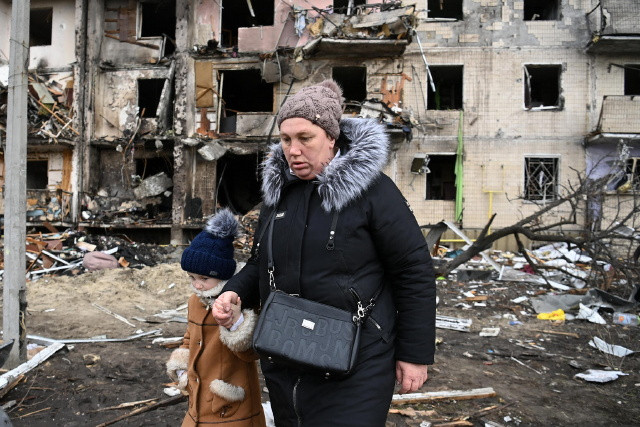 Unicef: Egy nő és gyermeke Kijev lebombázott külvárosában