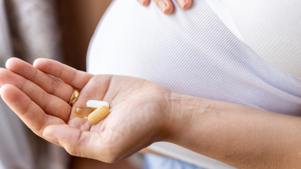 Terhes nő vitaminokkal a kezében Terhes nő vitaminokkal a kezében