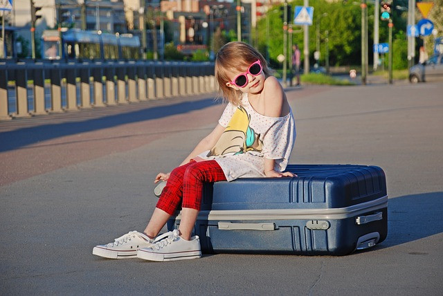 nyaraló kislány bőrönddel