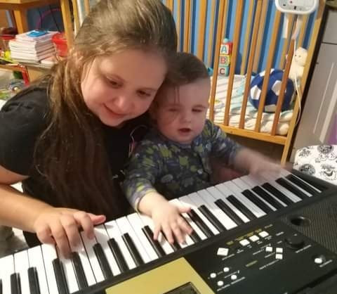 nagylány kisfiúval zongorázik